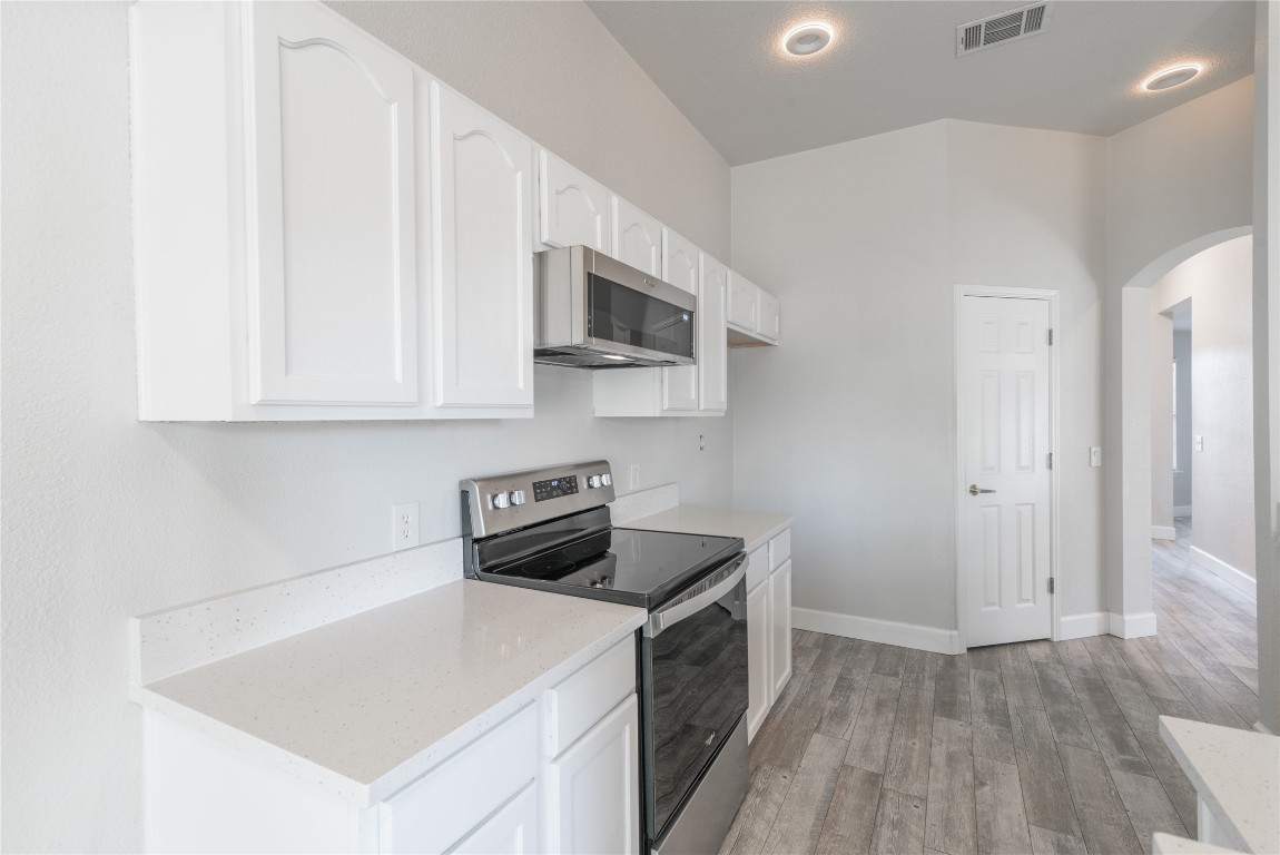 216 Brickyard Lane Jarrell, TX 76537 - Photo 6 of 33 a kitchen with stainless steel appliances a white stove top oven cabinets a sink and a microwave
