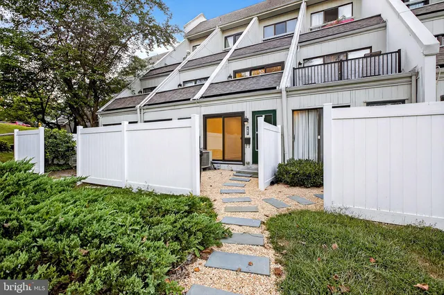 a view of a house with a small yard plants and large tree
