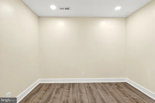 a view of an empty room with wooden floor