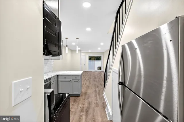 a view of a kitchen with furniture and a refrigerator