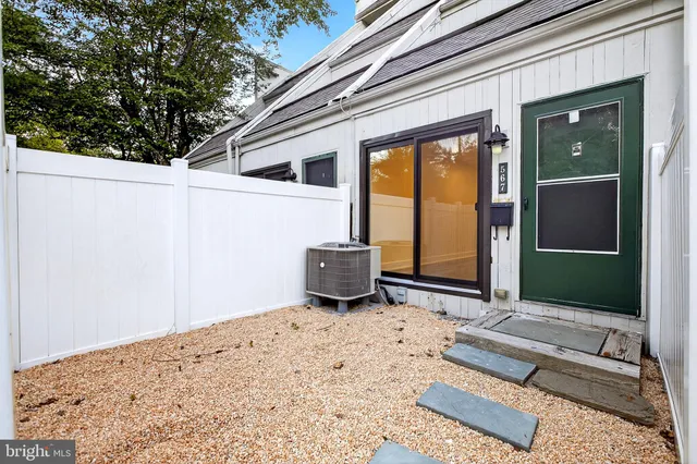 a view of a porch with a bench and floor to ceiling window