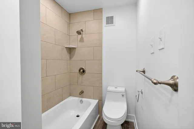 a white toilet sitting next to a bathroom sink and vanity