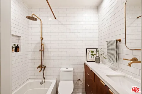 a bathroom with a granite countertop sink toilet and shower