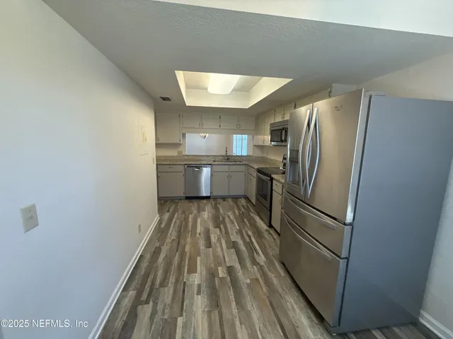a kitchen with a refrigerator and microwave