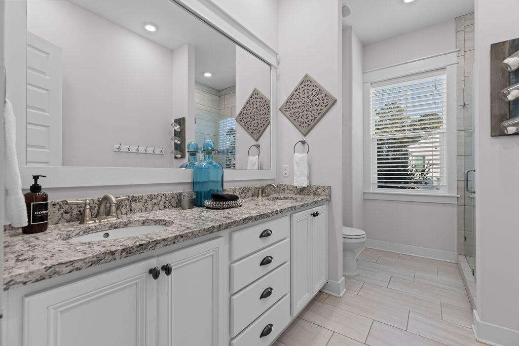 10 York Ln Inlet Beach, Unit B Inlet Beach, FL 32461 - Photo 25 of 46 a bathroom with a granite countertop sink mirror and a toilet