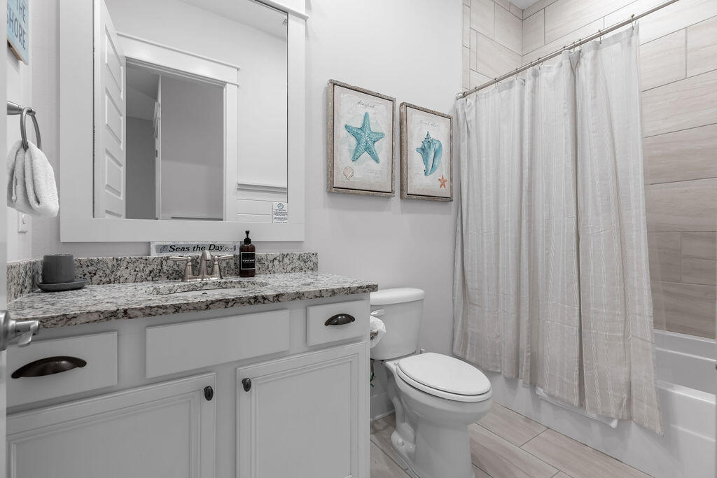 10 York Ln Inlet Beach, Unit B Inlet Beach, FL 32461 - Photo 33 of 46 a bathroom with a granite countertop toilet sink and mirror