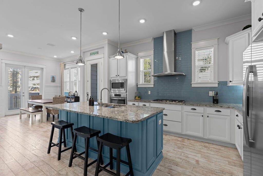 10 York Ln Inlet Beach, Unit B Inlet Beach, FL 32461 - Photo 5 of 46 a kitchen with stainless steel appliances granite countertop a table chairs sink refrigerator and cabinets