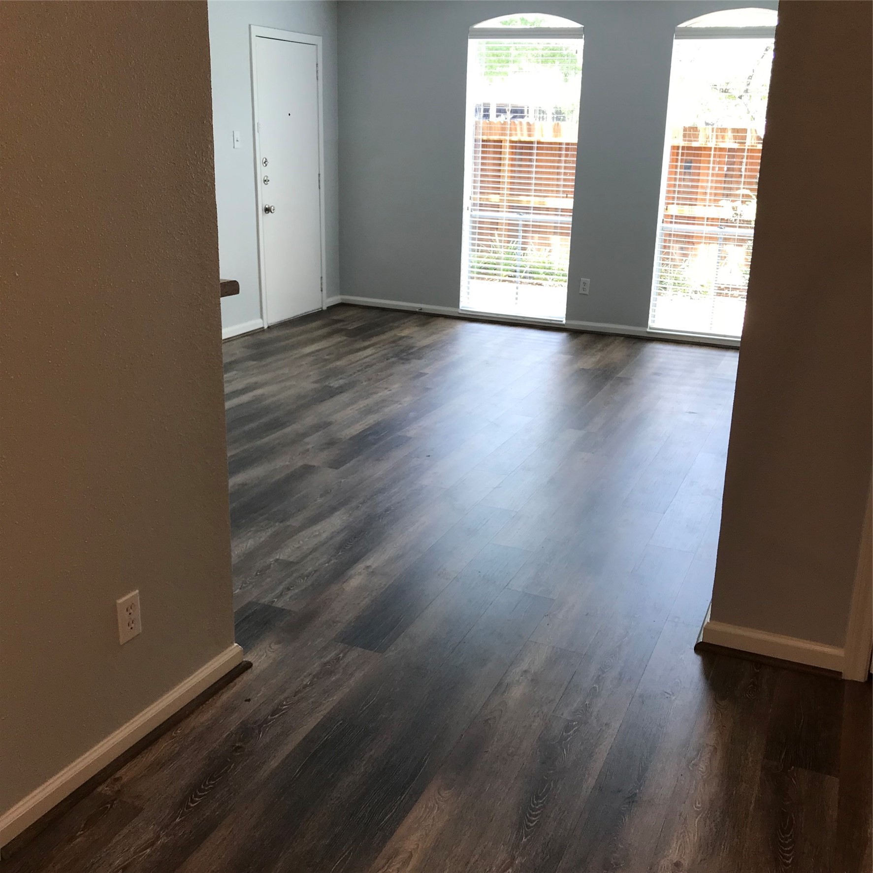 4631 Wild Indigo Street, Unit 560 Houston, TX 77027 - Photo 2 of 12 an empty room with wooden floor and windows with curtains