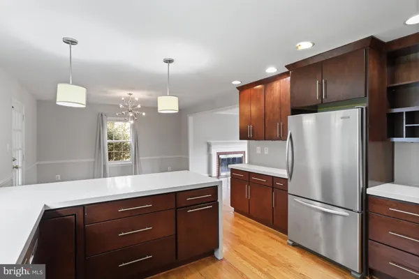 a kitchen with a refrigerator a sink and wooden floor