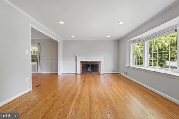 wooden floor fireplace and windows in an empty room