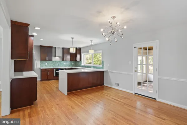 a large kitchen with stainless steel appliances granite countertop a refrigerator and a sink