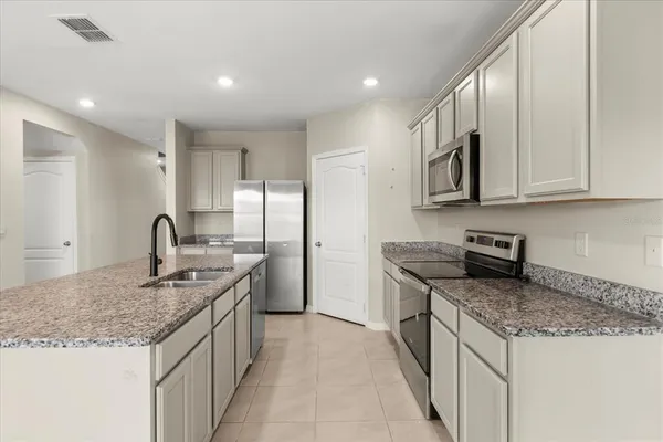 a kitchen with granite countertop kitchen island stainless steel appliances granite countertop a stove and a sink