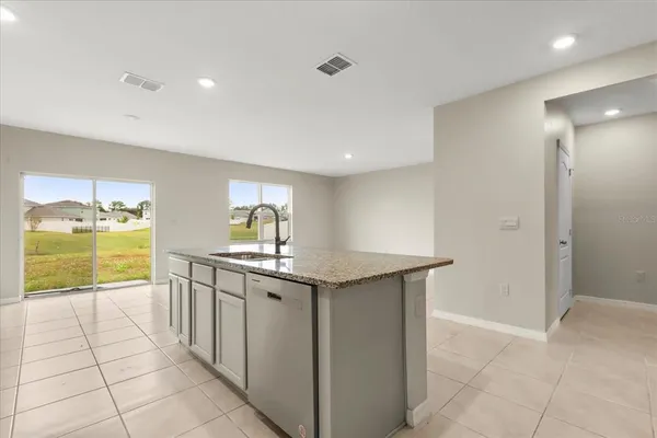 a kitchen with granite countertop a sink and cabinets