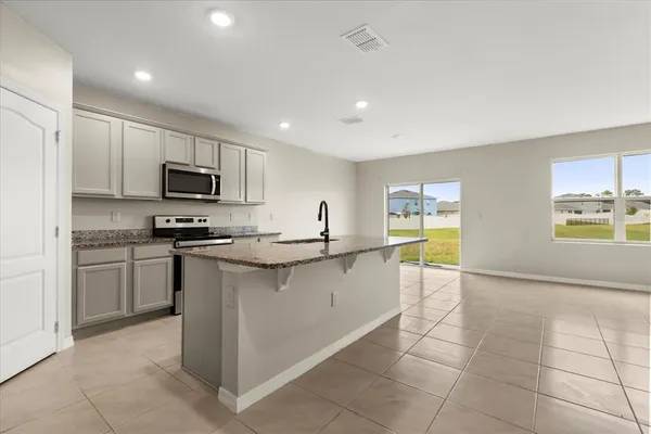 a kitchen with a sink a counter top space appliances and cabinets