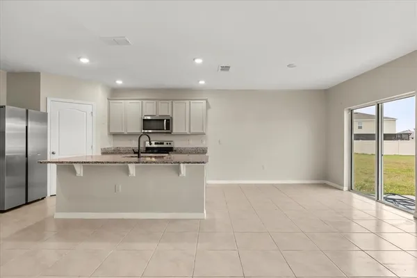 a kitchen with stainless steel appliances granite countertop a refrigerator sink and stove