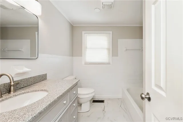 a bathroom with a granite countertop toilet a sink and mirror