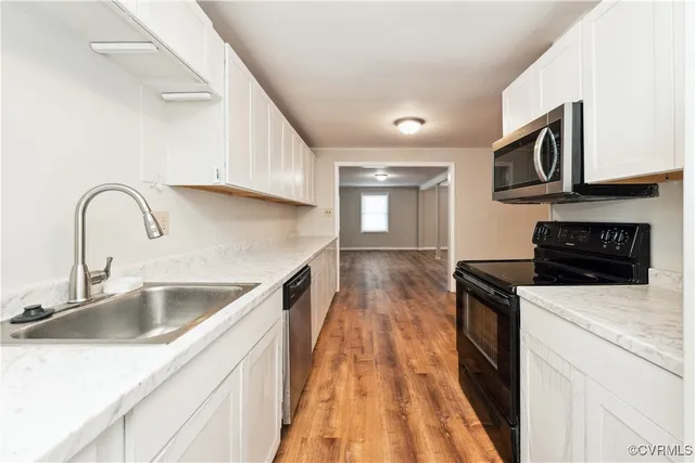 a kitchen with stainless steel appliances granite countertop a sink and a stove