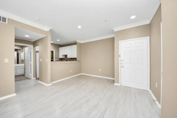 a view of an empty room with window and wooden floor