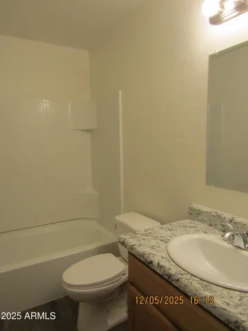 a bathroom with a granite countertop toilet and a sink