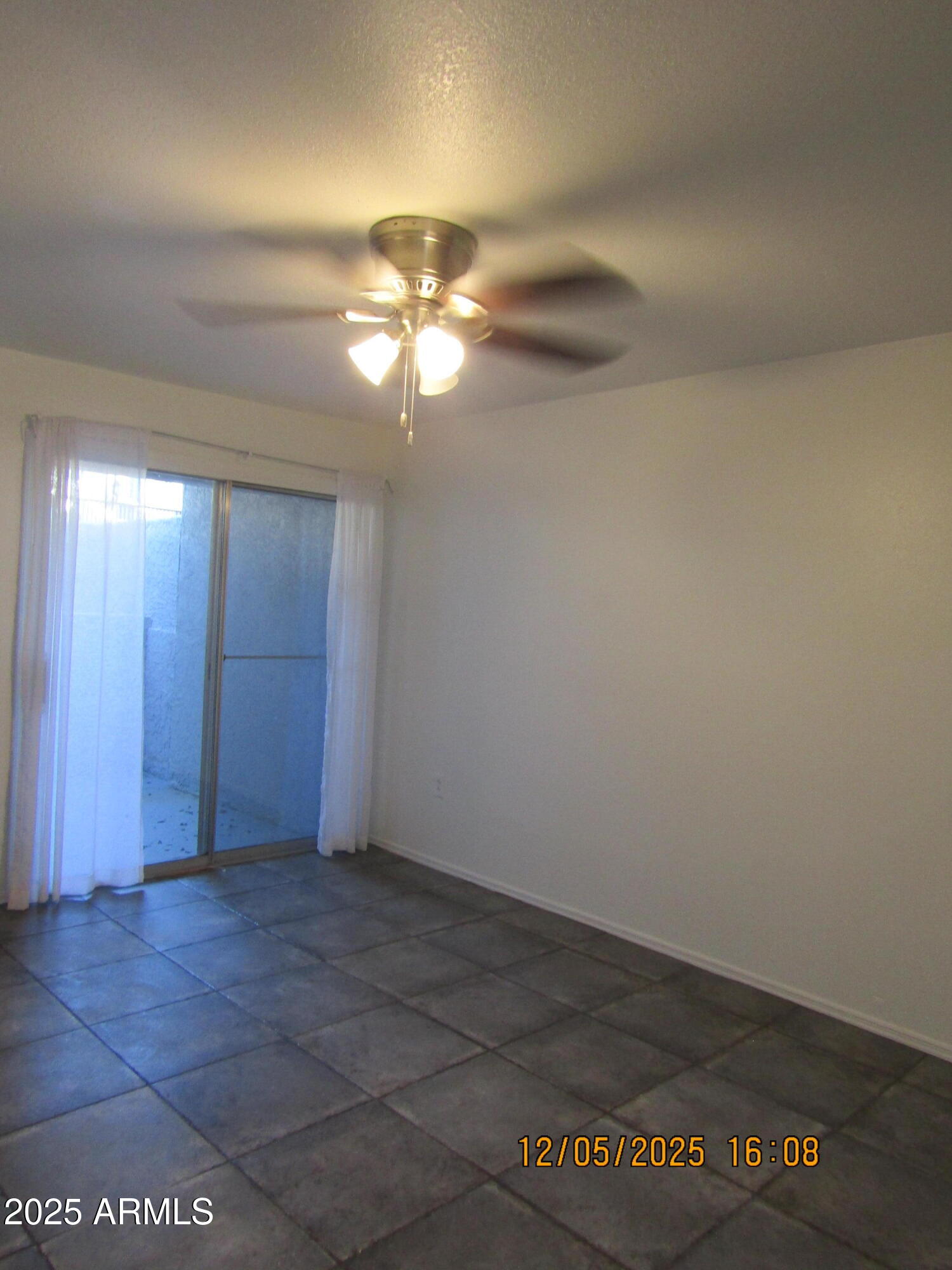 1331 West Baseline Road, Unit 102 Mesa, AZ 85202 - Photo 3 of 13 an empty room with a empty space and a ceiling fan
