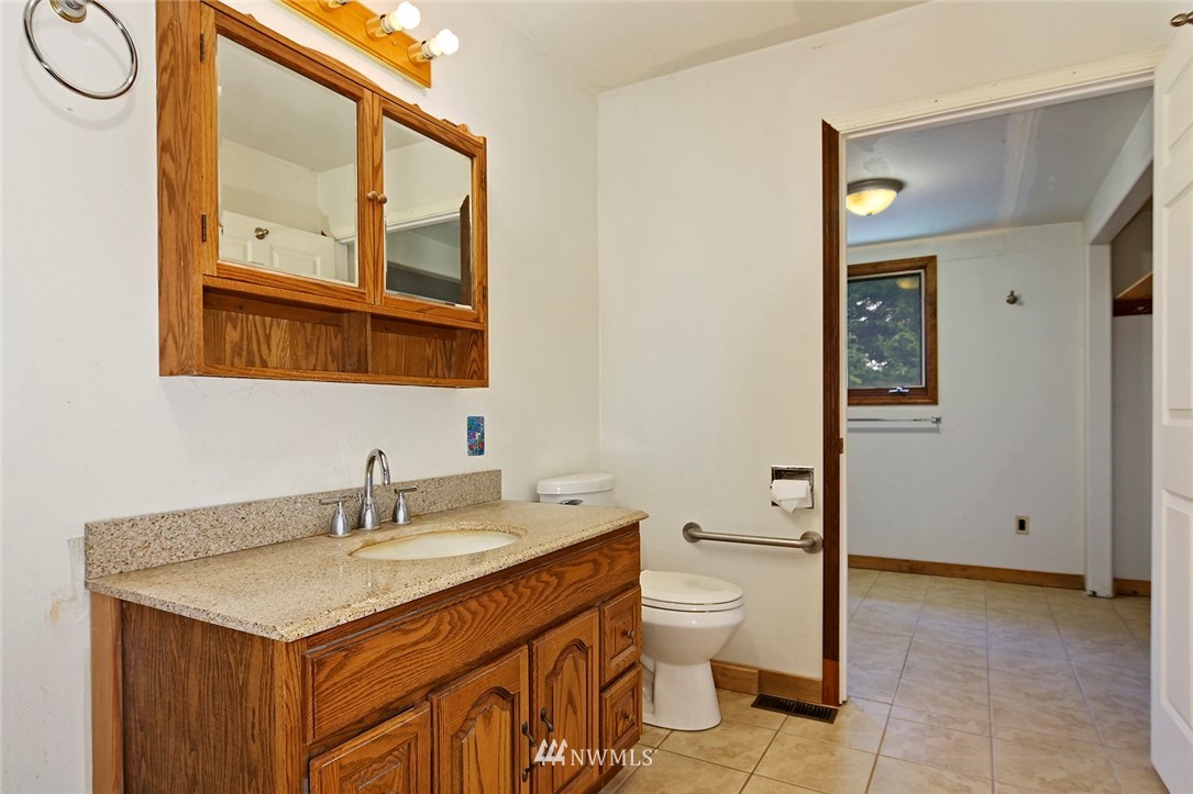 1000 Duchess Road Bothell, WA 98012 - Photo 22 of 35 a bathroom with a sink a toilet and a mirror