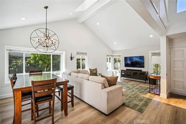 a living room with furniture a window and a dining table with wooden floor