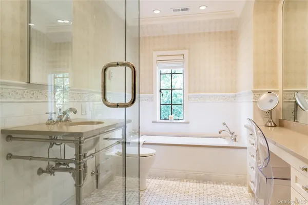 a bathroom with a tub sink and mirror