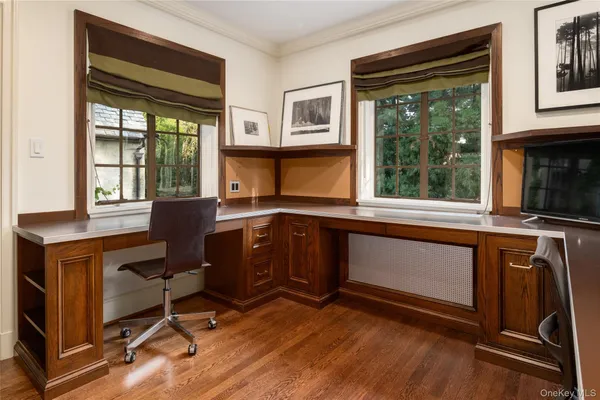 a view of a workspace with furniture and a window