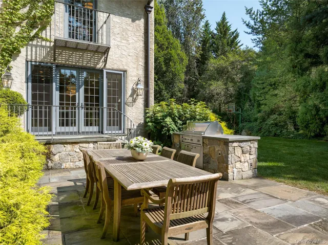 a patio with a table and chairs and potted plants
