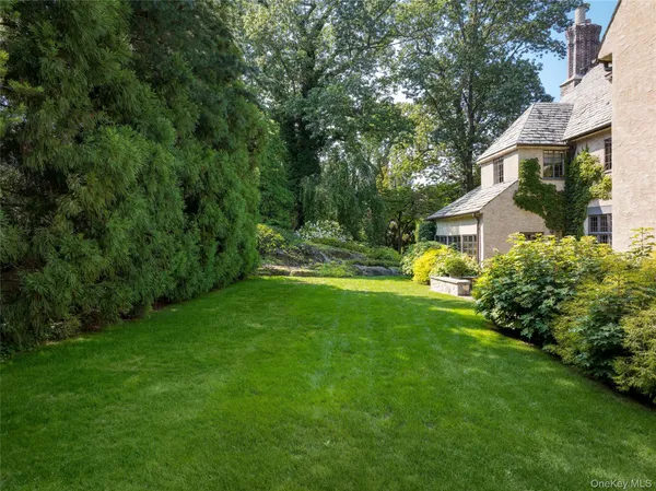 a view of a house with a big yard and sitting area