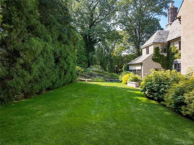 a view of a house with a big yard and sitting area