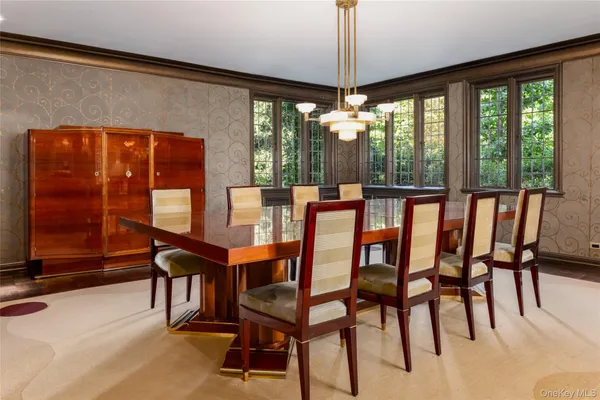 a dining room with furniture chandelier and glass door