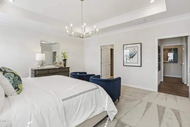 a bedroom with bed and a chandelier