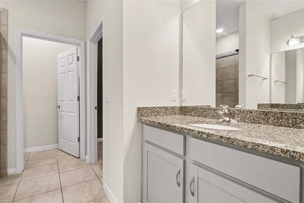 a bathroom with a granite countertop sink and a mirror