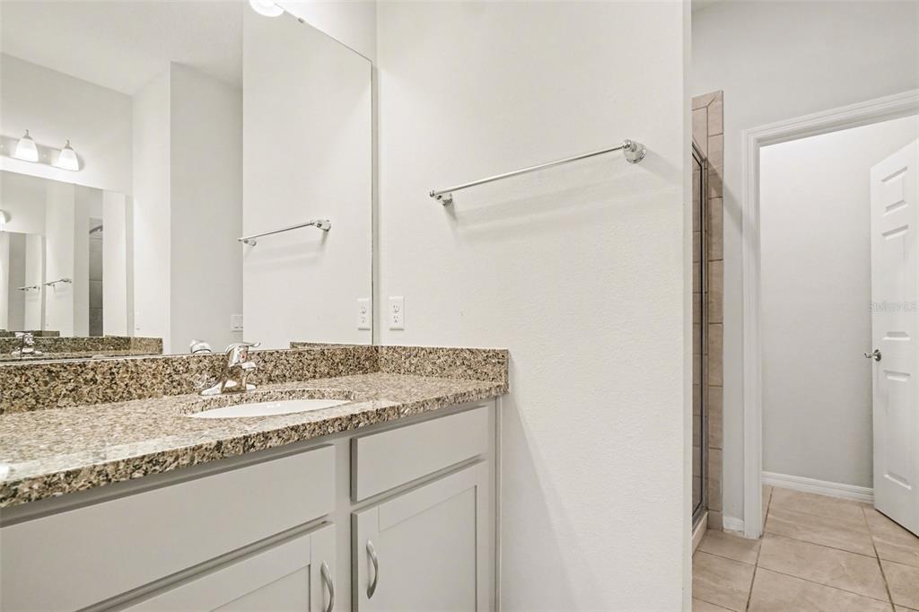 2735 Rowan Street Tavares, FL 32778 - Photo 12 of 32 a bathroom with a granite countertop sink and a mirror