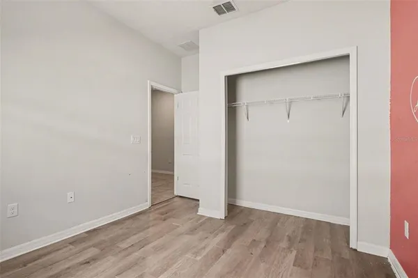 an empty room with wooden floor and closet