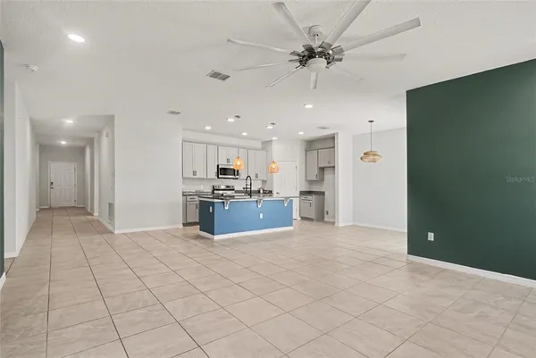 a view of kitchen with kitchen island stainless steel appliances refrigerator sink and cabinets