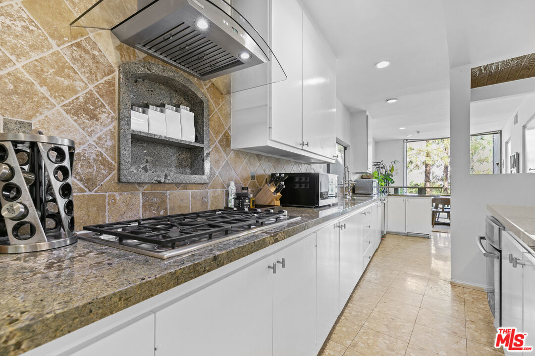 13952 Valley Vista Boulevard Sherman Oaks, CA 91423 - Photo 12 of 44 a kitchen with stainless steel appliances granite countertop a stove a sink and a microwave