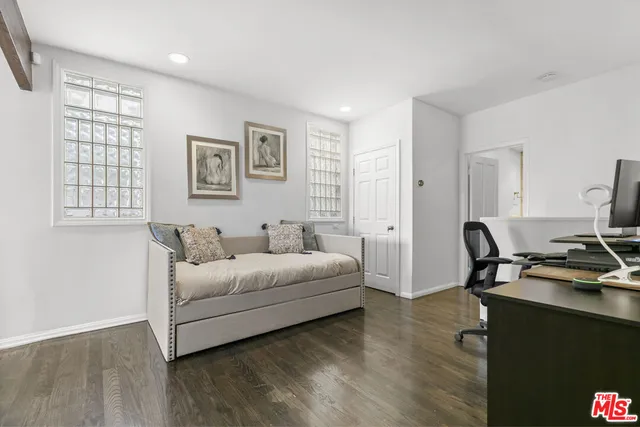 a living room with furniture a desk and chair with wooden floor