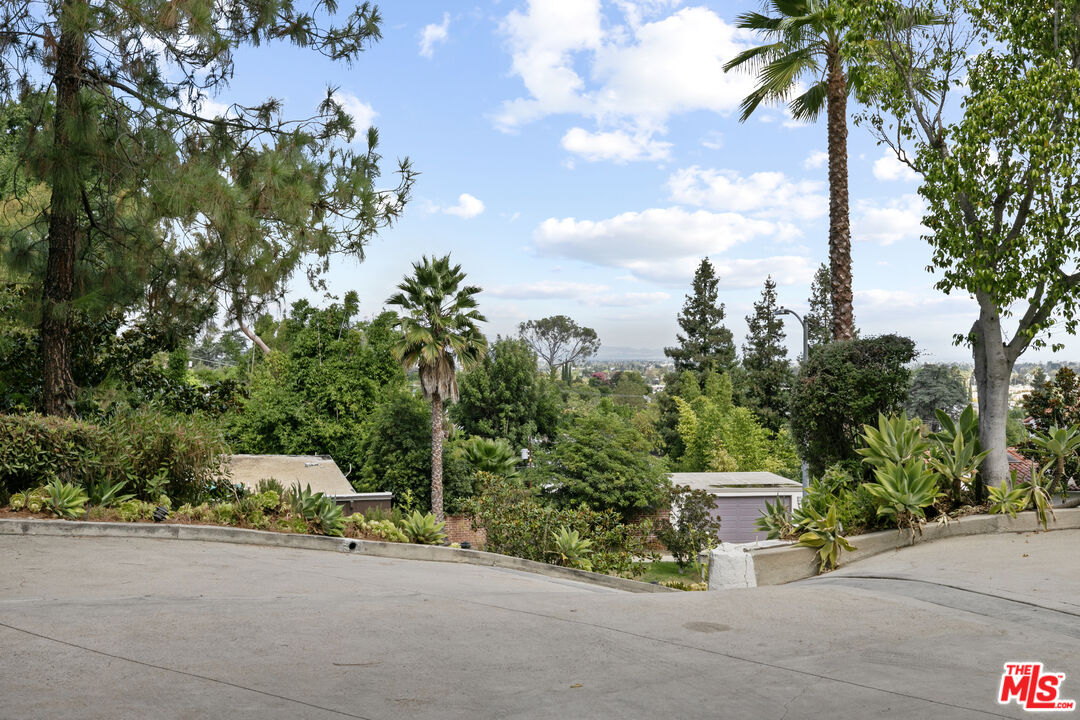 13952 Valley Vista Boulevard Sherman Oaks, CA 91423 - Photo 4 of 44 a white house with trees in front of it