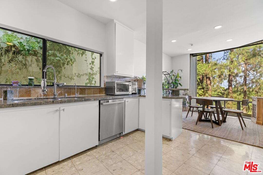 13952 Valley Vista Boulevard Sherman Oaks, CA 91423 - Photo 7 of 44 a dining hall with stainless steel appliances granite countertop a stove a sink a dining table and chairs with wooden floor