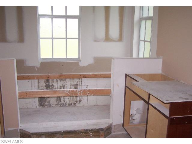 4620 8th Avenue Northeast Naples, FL 34120 - Photo 7 of 8 a bathroom with a granite countertop sink a mirror and a bathtub