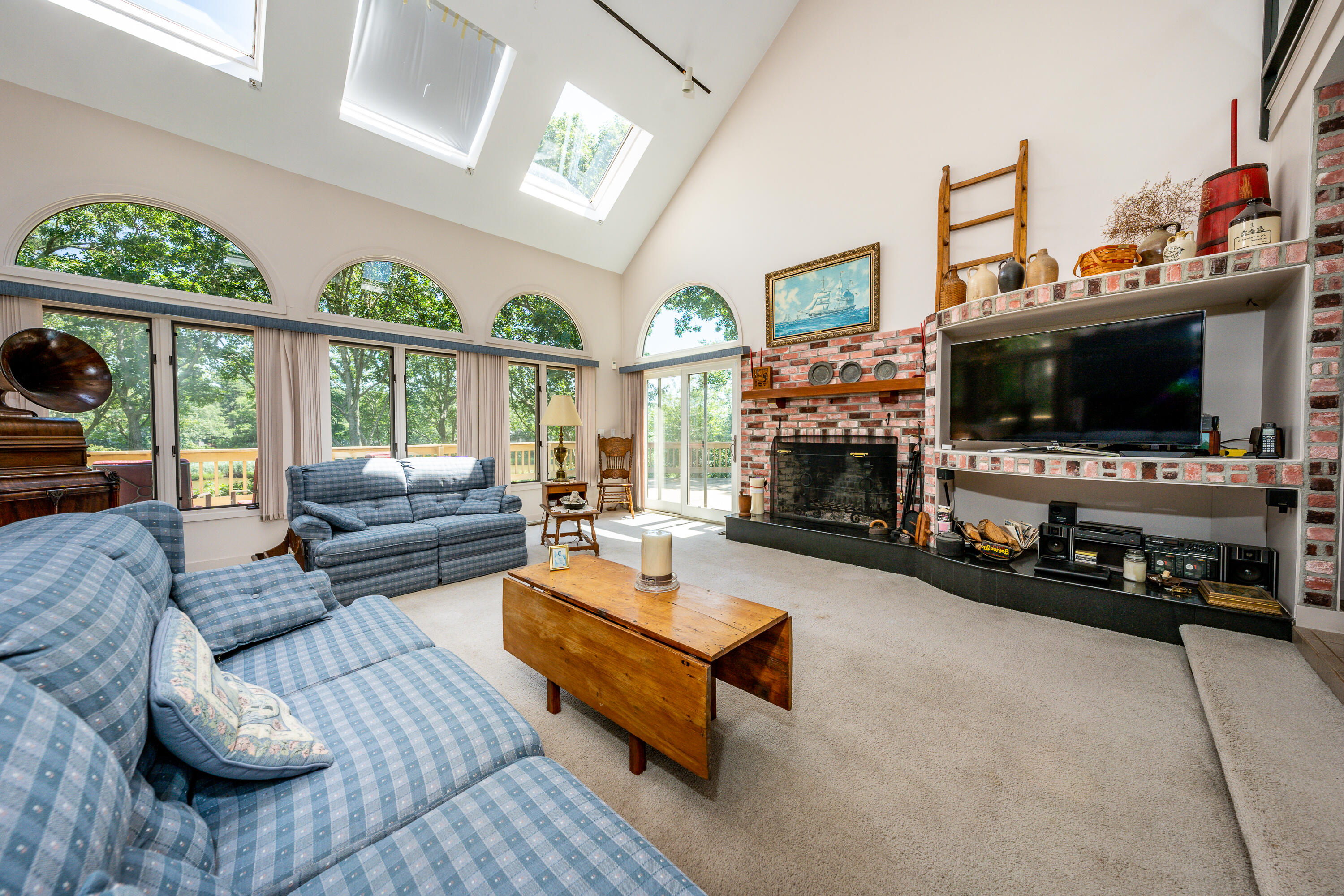 108 Waterside Drive Centerville, MA 02632 - Photo 16 of 64 a living room with furniture a fireplace a flat screen tv and a large window