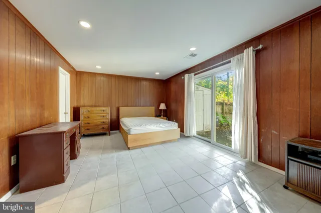 a spacious bedroom with a large bed and large windows