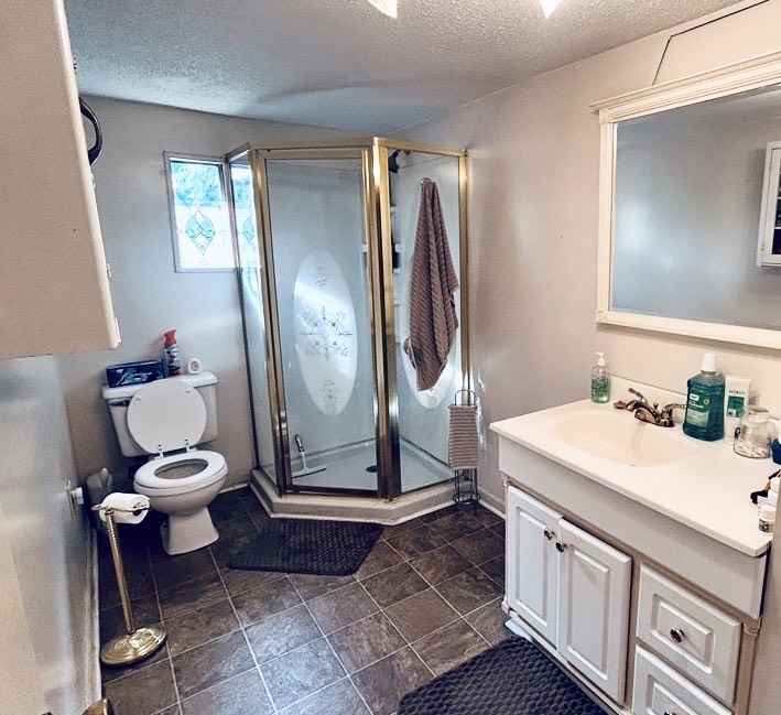 608 29 N Bypass Anderson, SC 29621 - Photo 3 of 20 A corner shower enclosure with a brass frame anchors this well-appointed bathroom, featuring a vanity and tiled flooring.