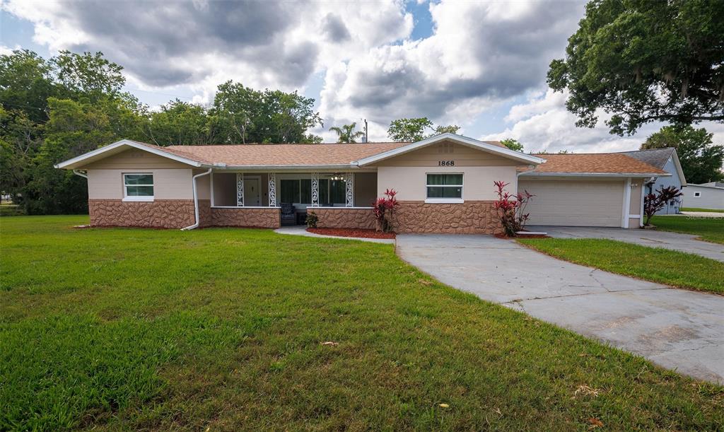 a front view of a house with a garden and yard