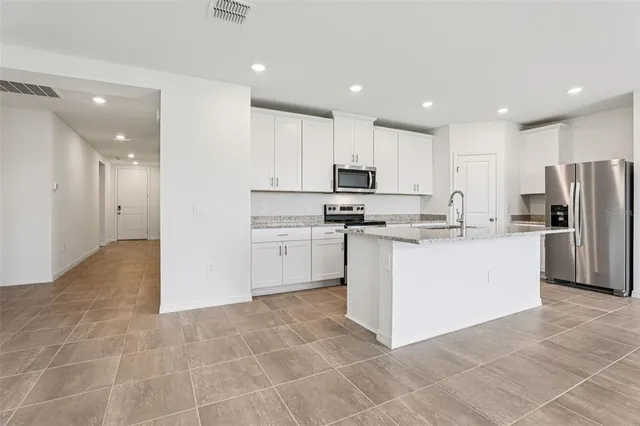 a kitchen with stainless steel appliances a refrigerator sink and microwave