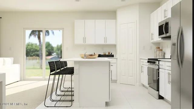 a kitchen with stainless steel appliances a stove a refrigerator and white cabinets
