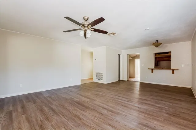 a view of a livingroom with wooden floor and a ceiling fan