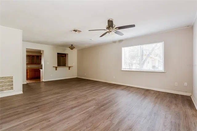 a view of empty room with wooden floor and window